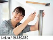 woman securing metal pole to support worktop. Стоковое фото, агентство Ingram Publishing / Фотобанк Лори