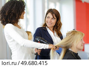 hairdressing apprentice drying customers hair. Стоковое фото, агентство Ingram Publishing / Фотобанк Лори