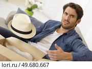portrait of displease birthday guy holding opened box. Стоковое фото, агентство Ingram Publishing / Фотобанк Лори