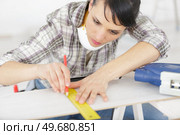 woman carpenter draws on wooden board. Стоковое фото, агентство Ingram Publishing / Фотобанк Лори