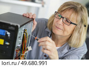 mature woman screws the inside of a pc. Стоковое фото, агентство Ingram Publishing / Фотобанк Лори