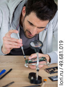 young man repairing motherboard from pc. Стоковое фото, агентство Ingram Publishing / Фотобанк Лори
