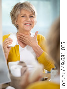 senior woman applying moisturiser to her neck. Стоковое фото, агентство Ingram Publishing / Фотобанк Лори
