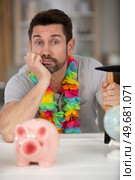 man resigned to smashing his piggybank for travel funds. Стоковое фото, агентство Ingram Publishing / Фотобанк Лори