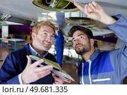 two male engineers inspecting underside of aircrafts wing. Стоковое фото, агентство Ingram Publishing / Фотобанк Лори