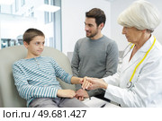 a female doctor checking little boy who came with father. Стоковое фото, агентство Ingram Publishing / Фотобанк Лори