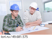 two labourers checking the documents. Стоковое фото, агентство Ingram Publishing / Фотобанк Лори