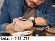 young handsome man checking the time on wrist watch. Стоковое фото, агентство Ingram Publishing / Фотобанк Лори