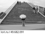 Девушка с зонтиком стоит спиной к лестнице, ведущей наверх. Весна, день. Черно-белое фото. Стоковое фото, фотограф Магомедрасул Кадиев / Фотобанк Лори