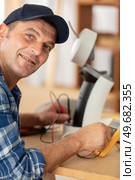 mature happy handsome technician repairing a broken coffee machine. Стоковое фото, агентство Ingram Publishing / Фотобанк Лори