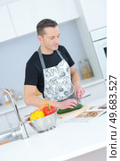 man following recipe and chopping courgette. Стоковое фото, агентство Ingram Publishing / Фотобанк Лори