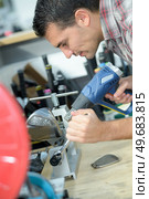 man using a heat gun to shape an object. Стоковое фото, агентство Ingram Publishing / Фотобанк Лори