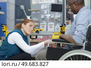 man on wheelchair receiving advice from seller. Стоковое фото, агентство Ingram Publishing / Фотобанк Лори
