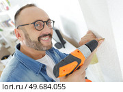 man drilling the wall with drill perforator. Стоковое фото, агентство Ingram Publishing / Фотобанк Лори