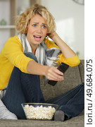 beautiful woman is frightened while watching a horror movie alone. Стоковое фото, агентство Ingram Publishing / Фотобанк Лори