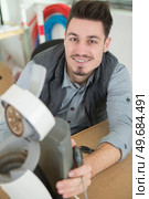 serious man repairing broken coffee machine. Стоковое фото, агентство Ingram Publishing / Фотобанк Лори