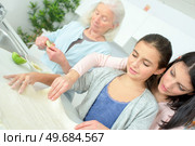 Three generations of women baking together. Стоковое фото, агентство Ingram Publishing / Фотобанк Лори