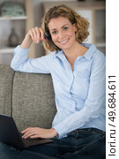 happy woman sitting on couch in living room. Стоковое фото, агентство Ingram Publishing / Фотобанк Лори