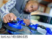 vehicle glazier using suction to remove the windshield. Стоковое фото, агентство Ingram Publishing / Фотобанк Лори