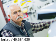 portrait of mechanic inspecting a vehicle. Стоковое фото, агентство Ingram Publishing / Фотобанк Лори