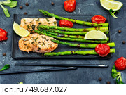 Baked trout and boiled asparagus on the plate. Mediterranean food. Salmon cooked with asparagus. Стоковое фото, агентство Ingram Publishing / Фотобанк Лори