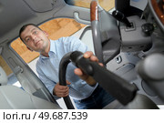 man hoovering seat of car during car cleaning. Стоковое фото, агентство Ingram Publishing / Фотобанк Лори