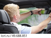 man adjusting the rearview mirror of the car. Стоковое фото, агентство Ingram Publishing / Фотобанк Лори