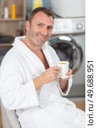 young relaxed handsome man oing laundry in the morning. Стоковое фото, агентство Ingram Publishing / Фотобанк Лори