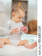 cute 6 month old baby playing with a teething toy. Стоковое фото, агентство Ingram Publishing / Фотобанк Лори