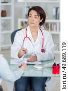sick woman complaining to doctor about symptoms of malaise. Стоковое фото, агентство Ingram Publishing / Фотобанк Лори
