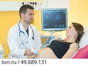 doctor doing 3d ultrasound on belly of pregnant woman. Стоковое фото, агентство Ingram Publishing / Фотобанк Лори