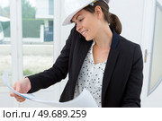 beatiful woman engineer with plans papers on building site. Стоковое фото, агентство Ingram Publishing / Фотобанк Лори