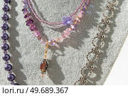 various fashionable author’s necklaces with precious stones and natural pearls are presented on a mannequin. fashion and handmade concept. close up. Стоковое фото, агентство Ingram Publishing / Фотобанк Лори