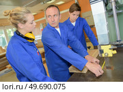 giving advise on using a band saw. Стоковое фото, агентство Ingram Publishing / Фотобанк Лори