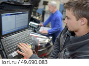 auto mechanic teacher and trainee performing tests at mechanic school. Стоковое фото, агентство Ingram Publishing / Фотобанк Лори
