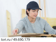 portrait of happy female woodworker drafting new project at workshop. Стоковое фото, агентство Ingram Publishing / Фотобанк Лори