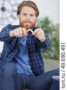 man breaking cigarette. Стоковое фото, агентство Ingram Publishing / Фотобанк Лори