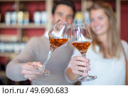 close up of couple clinking glasses in wine shop. Стоковое фото, агентство Ingram Publishing / Фотобанк Лори