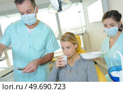 dentist curing a woman patient in the dental office. Стоковое фото, агентство Ingram Publishing / Фотобанк Лори