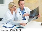 medical workers in office conferring over xray. Стоковое фото, агентство Ingram Publishing / Фотобанк Лори