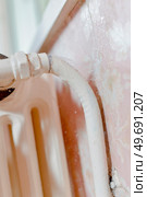 male worker is fixing a leaky radiator. Стоковое фото, агентство Ingram Publishing / Фотобанк Лори