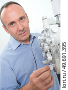 an optician setting up equipment. Стоковое фото, агентство Ingram Publishing / Фотобанк Лори