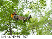 young woman zip-lining during tree top adventure. Стоковое фото, агентство Ingram Publishing / Фотобанк Лори