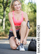 happy woman lacing her sport shoes. Стоковое фото, агентство Ingram Publishing / Фотобанк Лори