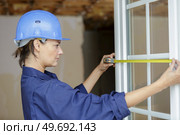 professional woman measuring pvc window. Стоковое фото, агентство Ingram Publishing / Фотобанк Лори