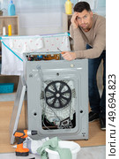 concept man stressed next to washing machine. Стоковое фото, агентство Ingram Publishing / Фотобанк Лори