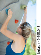 women climbs a route at the outdoor climbing wall. Стоковое фото, агентство Ingram Publishing / Фотобанк Лори