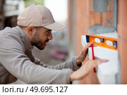 contractor using spirit level on window sill. Стоковое фото, агентство Ingram Publishing / Фотобанк Лори