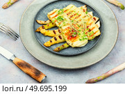 Delicious dish of baked white asparagus, halloumi cheese decorated with microgreens.. White asparagus with halloumi cheese. Стоковое фото, агентство Ingram Publishing / Фотобанк Лори
