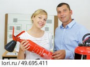 woman and man holding fire extinguishers. Стоковое фото, агентство Ingram Publishing / Фотобанк Лори
